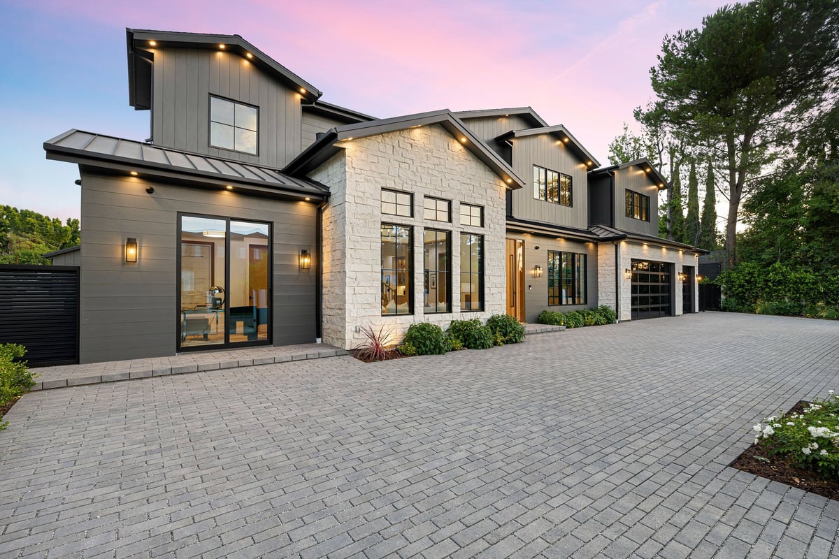 Kennesaw-style suburban home with a large driveway at sunset